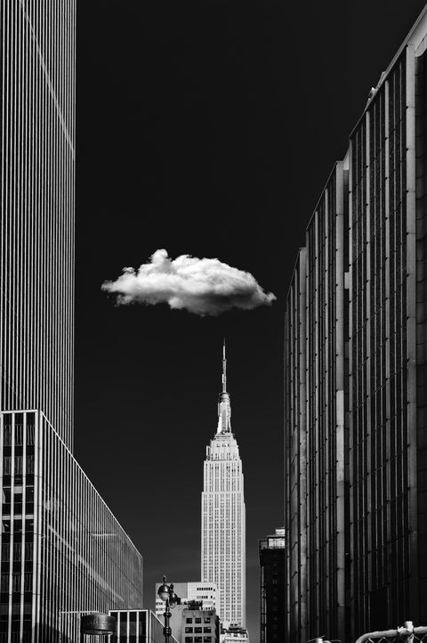 Obra final Single Cloud: o Empire State em preto e branco, céu preto absoluto e uma nuvem solitária